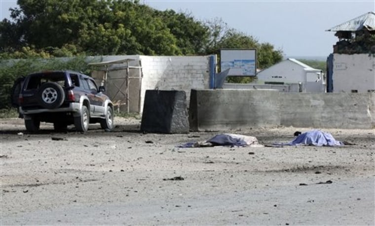 Two bodies lie in front of the Mogadishu airport gate on Thursday. A suicide car bomber and gunmen attacked the front gate to Mogadishu's seaside airport on Thursday, triggering an explosion and gunbattle, officials said. Several people were killed, including security forces. 